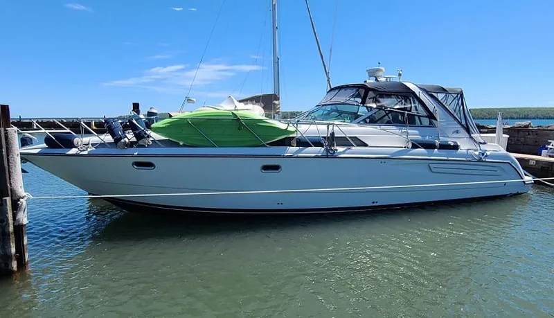 The Image of 1999 Bayliner 4085 Avanti yacht docked in a marina on a sunny day. - 0