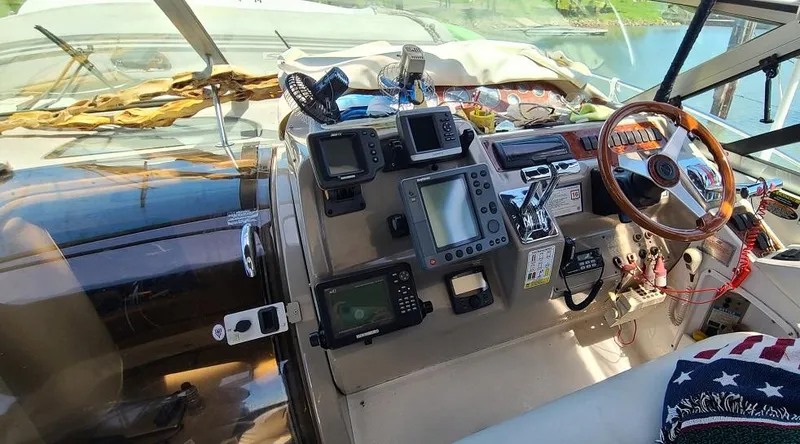 Slide: The Image of 1999 Bayliner 4085 Avanti boat cockpit with navigation equipment and wooden steering wheel. - 11