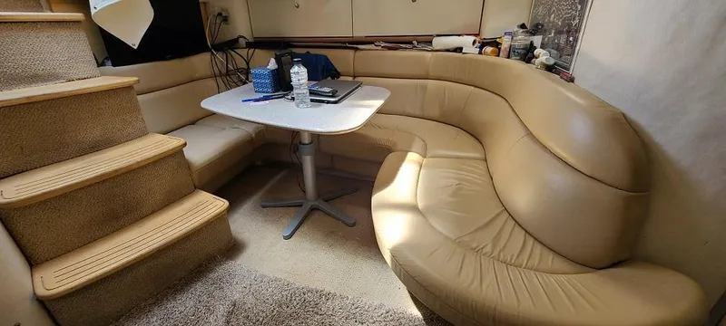 Slide: The Image of 1999 Bayliner 4085 Avanti interior with beige leather seating and dining table. - 18