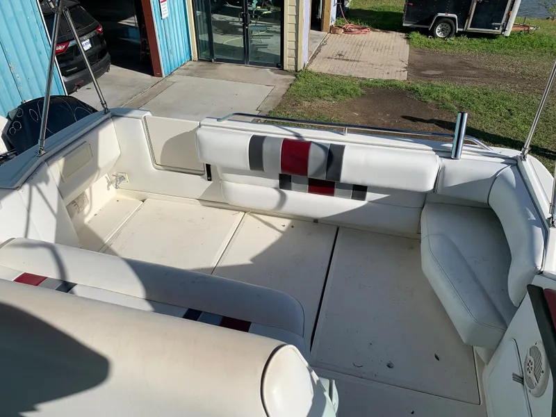 Slide: The Image of 1991 Sea Ray 290 Sundancer boat interior with white seating and striped accents. - 12