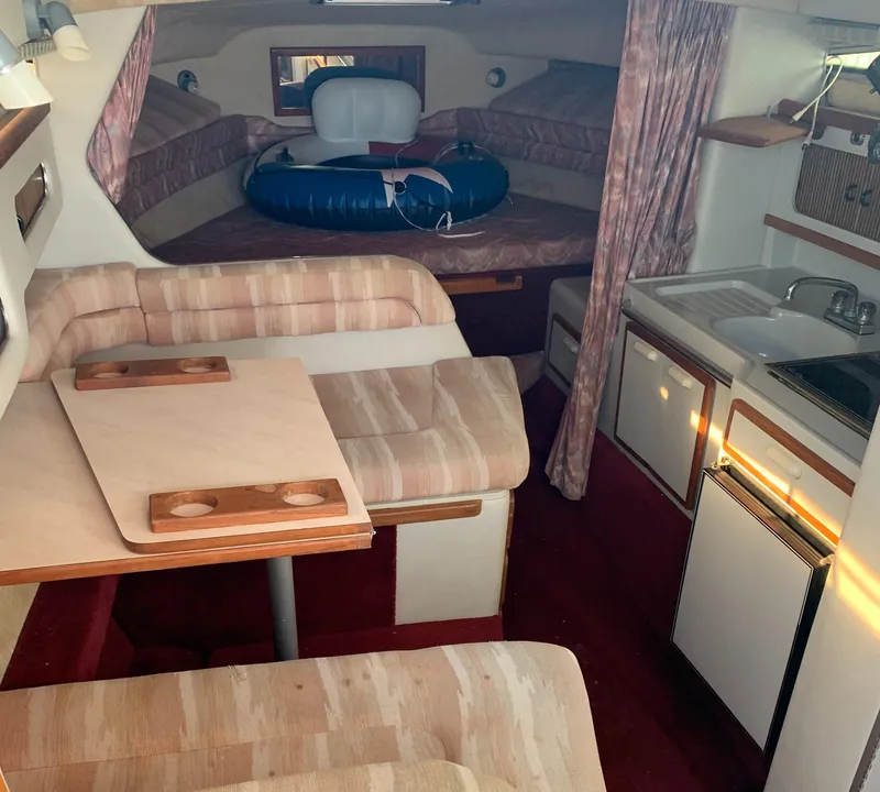 Slide: The Image of 1991 Sea Ray 290 Sundancer cabin interior with seating, table, and kitchenette. - 15