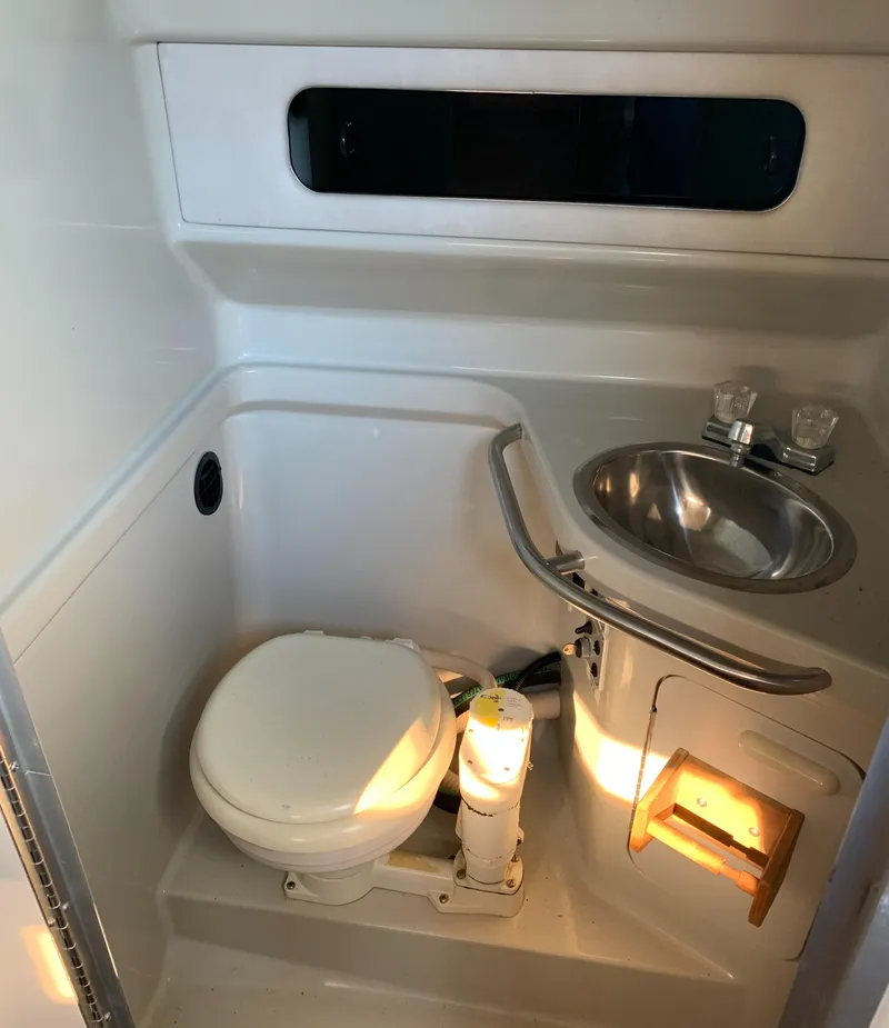 Slide: The Image of 1991 Sea Ray 290 Sundancer bathroom with toilet, sink, and window. - 21