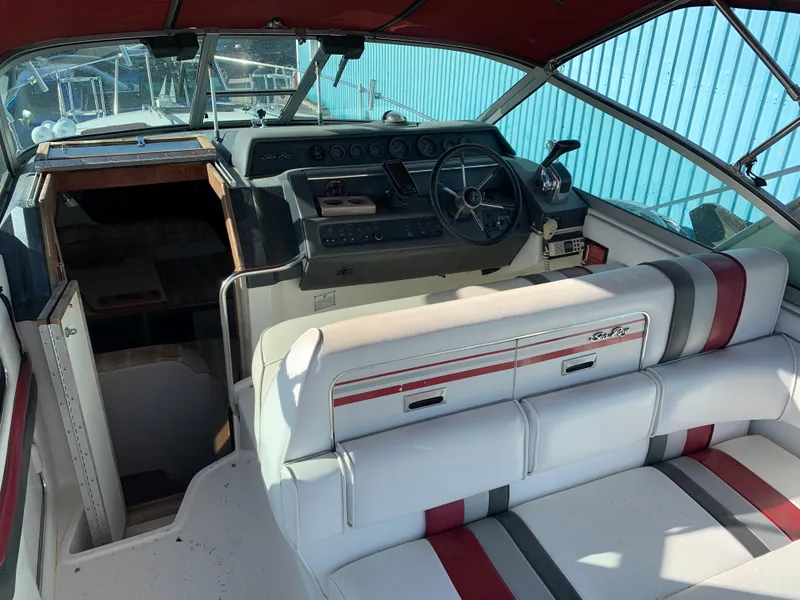 Slide: The Image of 1991 Sea Ray 290 Sundancer boat interior with helm, seating, and cabin entrance. - 3