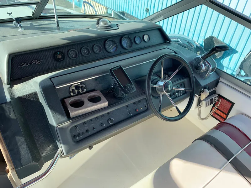 Slide: The Image of 1991 Sea Ray 290 Sundancer helm with steering wheel, gauges, and navigation equipment. - 4