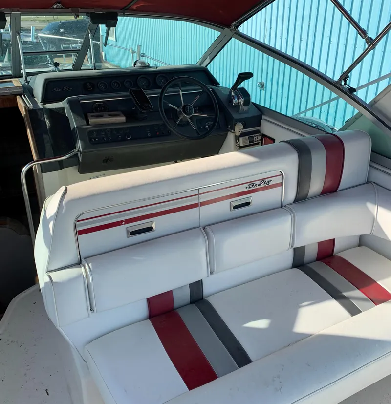 Slide: The Image of 1991 Sea Ray 290 Sundancer interior with white seating and striped accents. - 8