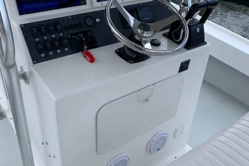 Slide: The Image of Dusky 28xl 2011 boat console with steering wheel, control panel, and seating. - 3