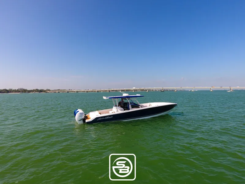 The Image of 2021 Nor-Tech 390 Sport boat on calm green water under clear blue sky. - 1