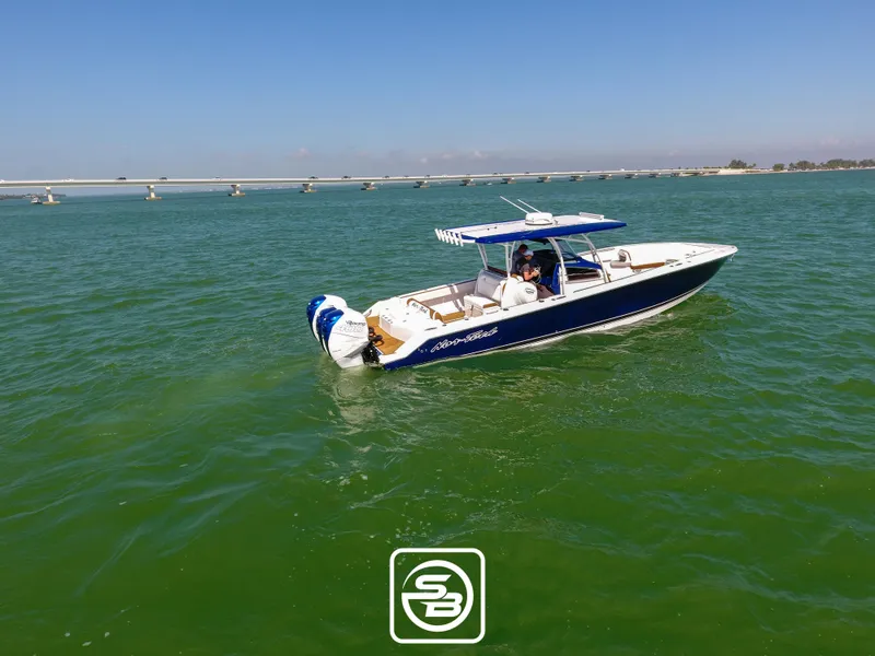 Slide: The Image of 2021 Nor-Tech 390 Sport boat cruising on green water with a bridge in the background. - 12