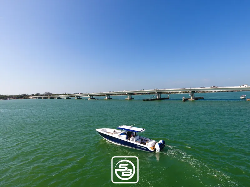 Slide: The Image of Nor-Tech 390 Sport 2021 boat cruising on a sunny day near a bridge. - 21