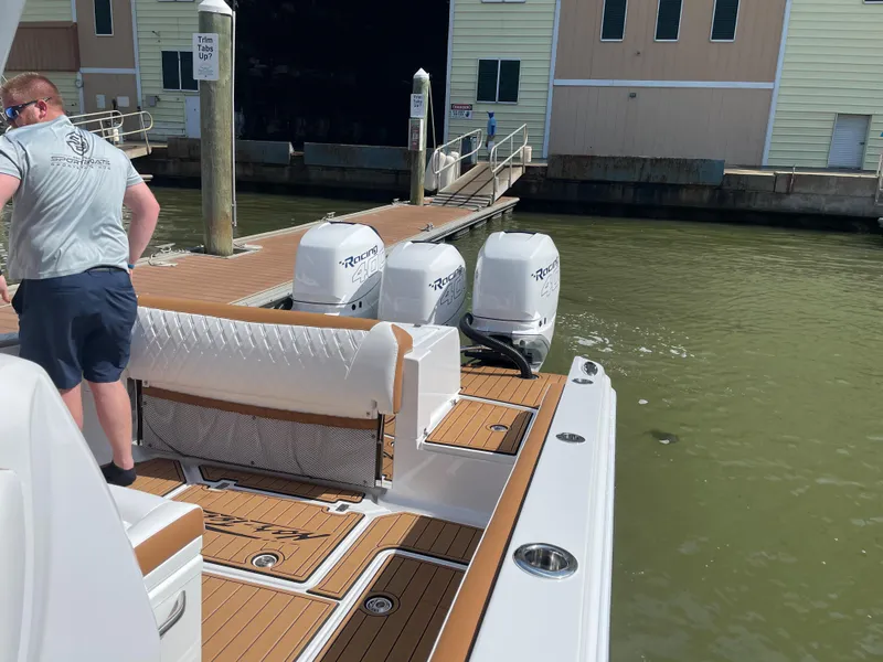 Slide: The Image of 2021 Nor-Tech 390 Sport boat docked with triple outboard engines. - 29