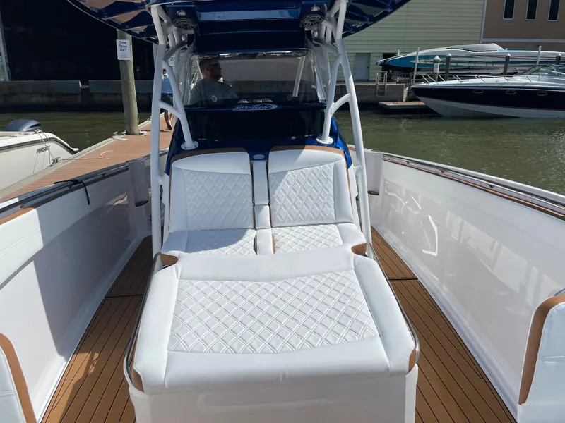 Slide: The Image of 2021 Nor-Tech 390 Sport boat with white cushioned seating at the dock. - 32