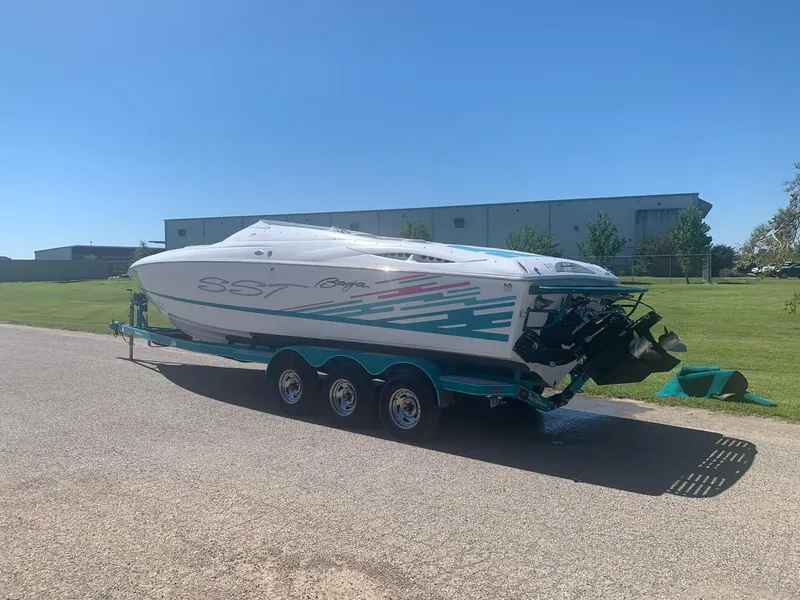 Slide: The Image of 1999 Baja 29 Outlaw SST speedboat on a trailer in a parking lot. - 10