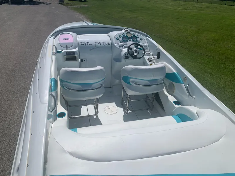 Slide: The Image of 1999 Baja 29 Outlaw SST boat interior with white and teal seating. - 11