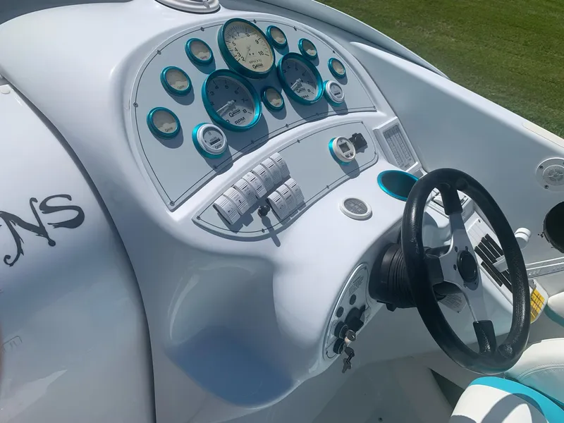 Slide: The Image of 1999 Baja 29 Outlaw SST boat dashboard with gauges and steering wheel. - 13