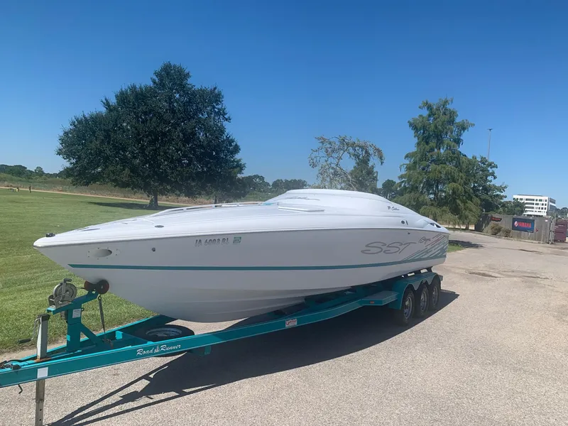 Slide: The Image of 1999 Baja 29 Outlaw SST speedboat on a trailer in a sunny outdoor setting. - 2