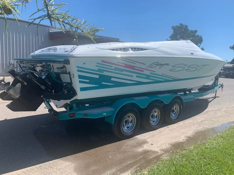 Slide: The Image of 1999 Baja 29 Outlaw SST speedboat on a triple-axle trailer, side view. - 23