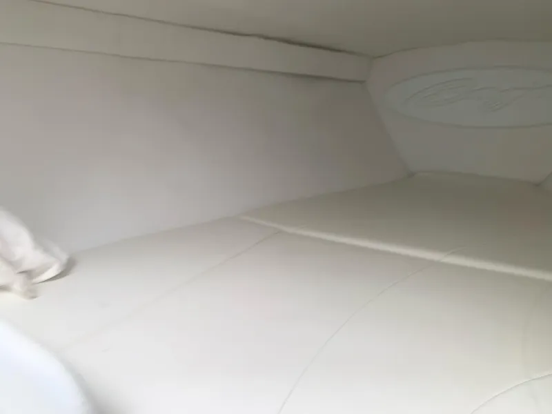 Slide: The Image of Interior cabin of a 1999 Baja 29 Outlaw SST boat with white upholstery. - 26
