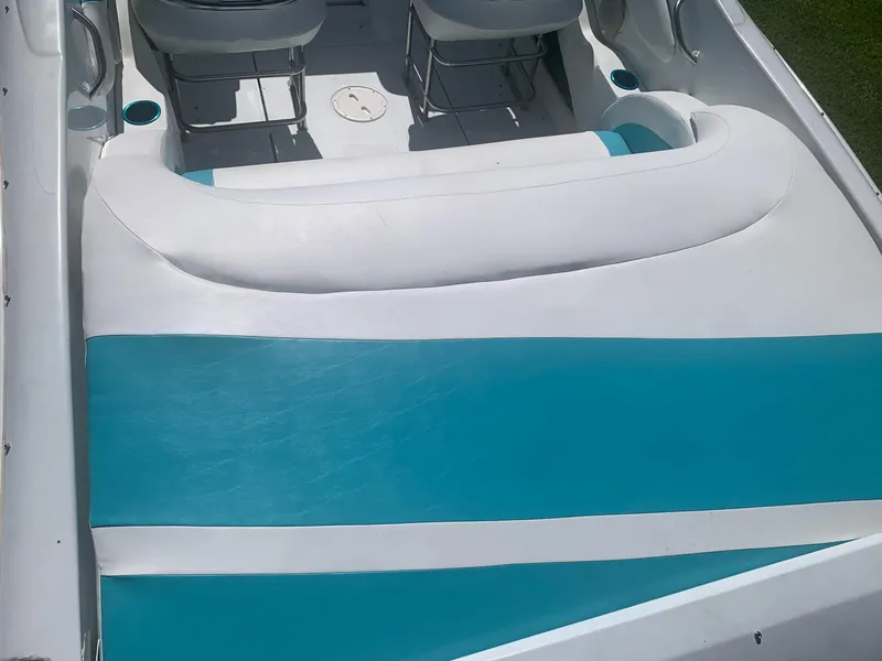 Slide: The Image of 1999 Baja 29 Outlaw SST boat interior with white and teal seating. - 32