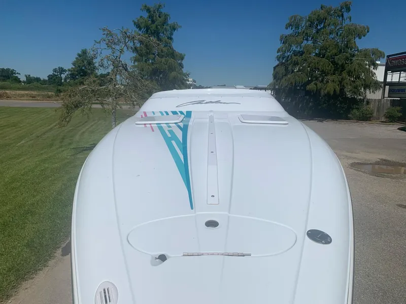 Slide: The Image of 1999 Baja 29 Outlaw SST boat, top view, white with teal and pink accents. - 35