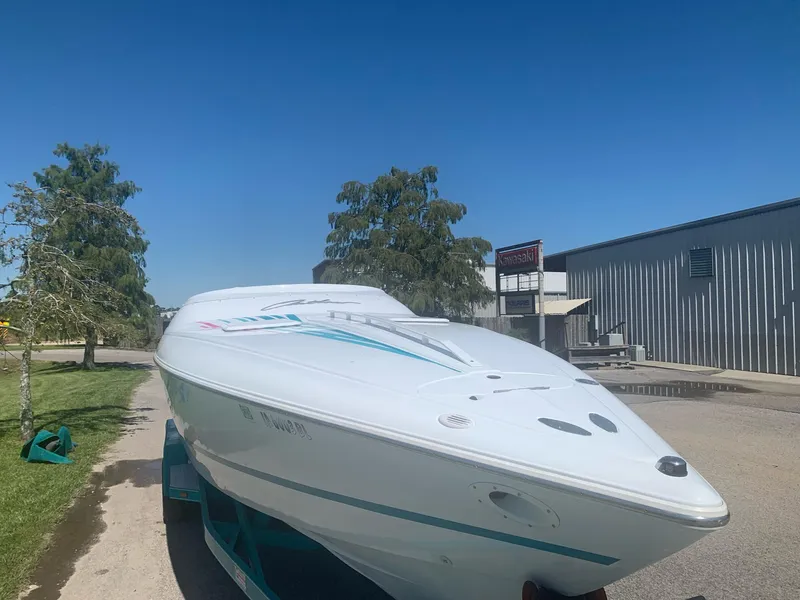 Slide: The Image of 1999 Baja 29 Outlaw SST speedboat on trailer, parked outdoors. - 36