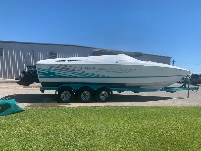 Slide: The Image of 1999 Baja 29 Outlaw SST speedboat on a trailer, parked outdoors. - 4