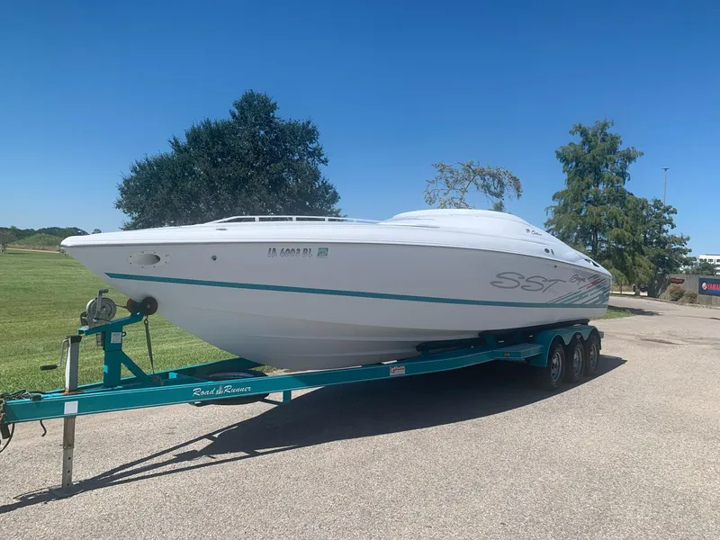 Slide: The Image of 1999 Baja 29 Outlaw SST speedboat on a trailer in a sunny outdoor setting. - 9
