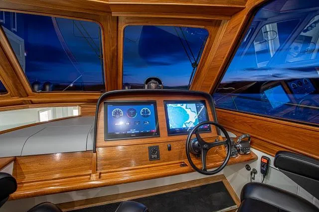 Slide: The Image of Helm of 2027 C.W. Hood 57 LM yacht with modern navigation displays and wooden finish. - 12
