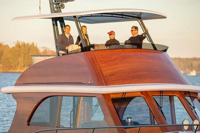 Slide: The Image of Four people on a 2027 C.W. Hood 57 LM yacht, enjoying a scenic view. - 6