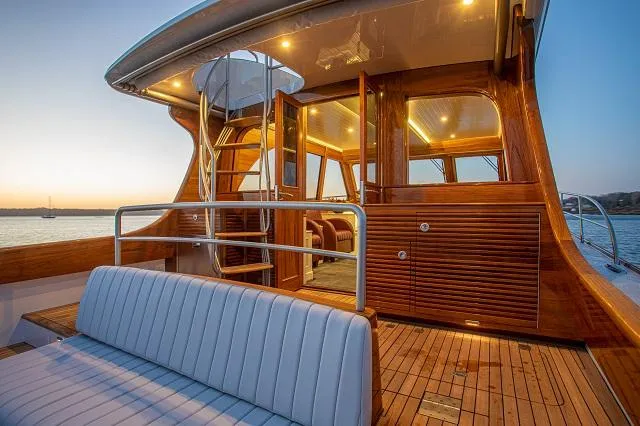 Slide: The Image of Luxurious 2027 C.W. Hood 57 LM yacht with elegant wooden interior and sunset view. - 9