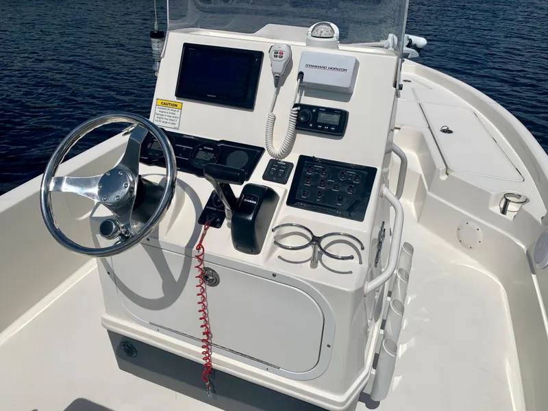 Slide: The Image of Control console of a 2016 Skeeter SX230 boat with steering wheel and navigation equipment. - 18