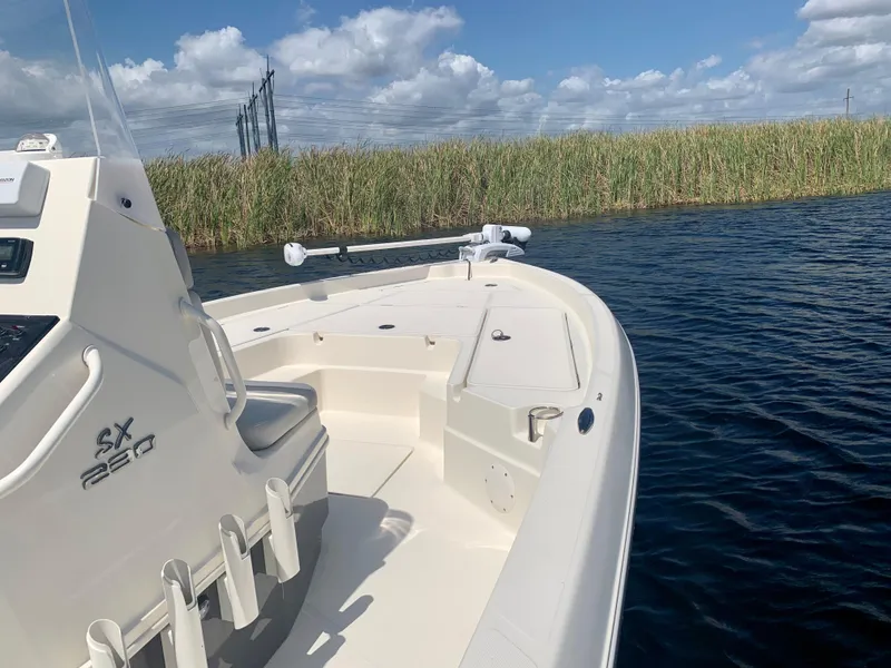 Slide: The Image of 2016 Skeeter SX230 boat on calm water with reeds in the background. - 20