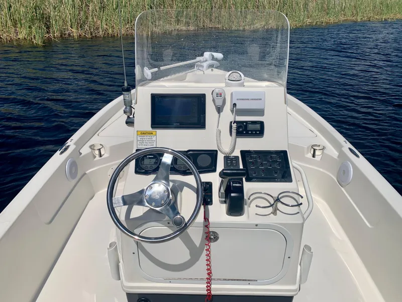 Slide: The Image of 2016 Skeeter SX230 boat console with steering wheel and navigation equipment. - 21