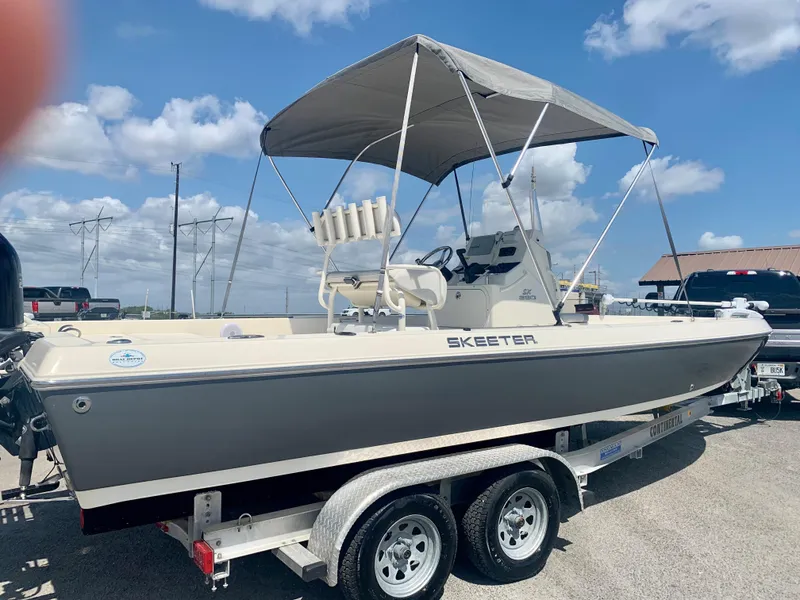 Slide: The Image of 2016 Skeeter SX230 boat on trailer with canopy under blue sky. - 3