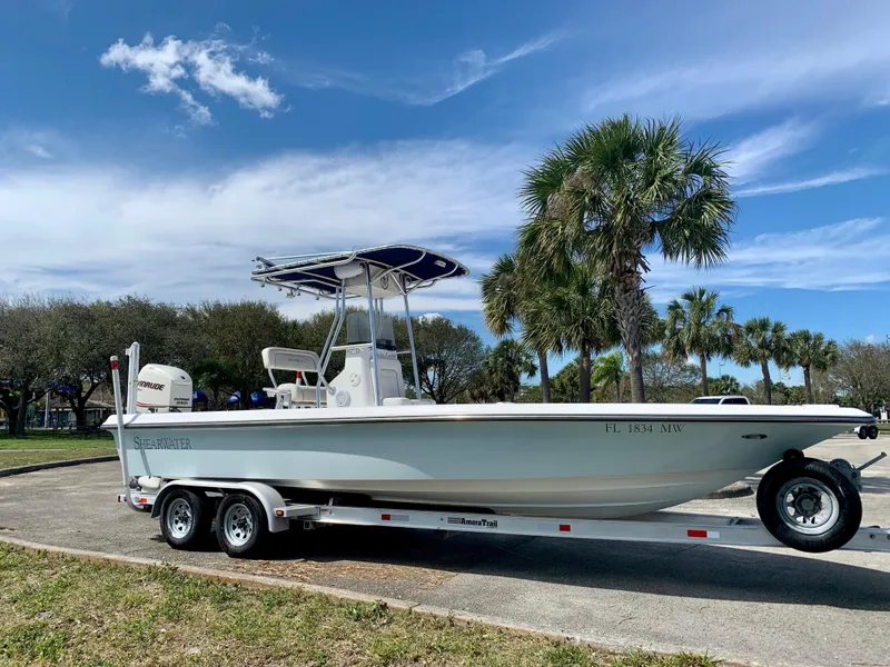 Slide: The Image of 2005 ShearWater z2400 boat on trailer with palm trees in background. - 1