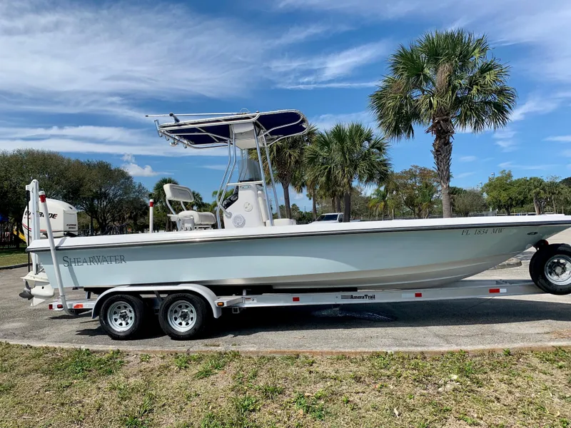Slide: The Image of 2005 ShearWater z2400 boat on a trailer with palm trees in the background. - 11