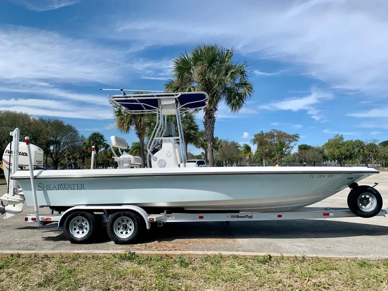 Slide: The Image of 2005 ShearWater z2400 boat on a trailer with palm trees in the background. - 2
