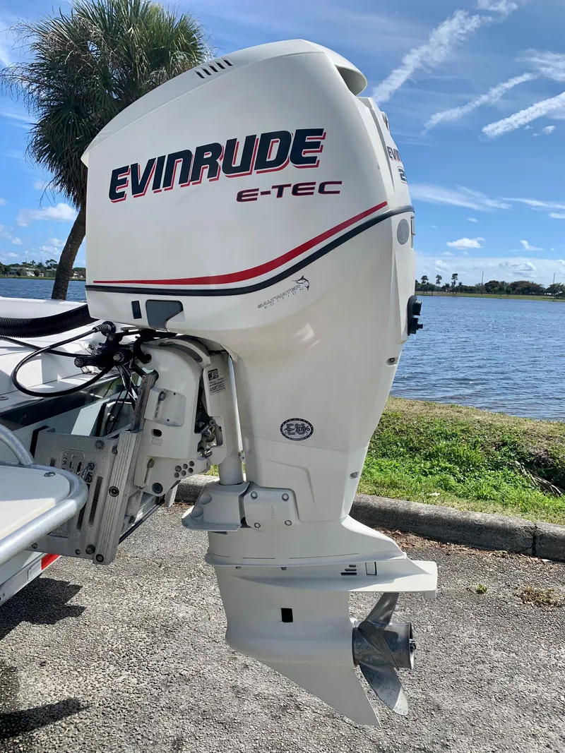 Slide: The Image of Evinrude E-TEC outboard motor on a 2005 ShearWater z2400 boat by a lake. - 5