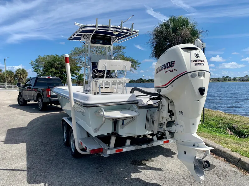Slide: The Image of 2005 ShearWater z2400 boat with Evinrude 250 engine on trailer by a lake. - 9