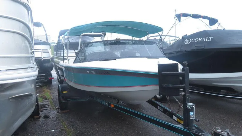 Slide: The Image of 1990 Nautique Ski boat on trailer, teal and white, with canopy. - 0