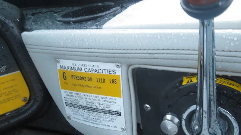 Slide: The Image of 1990 Nautique Ski boat capacity label and control lever. - 3