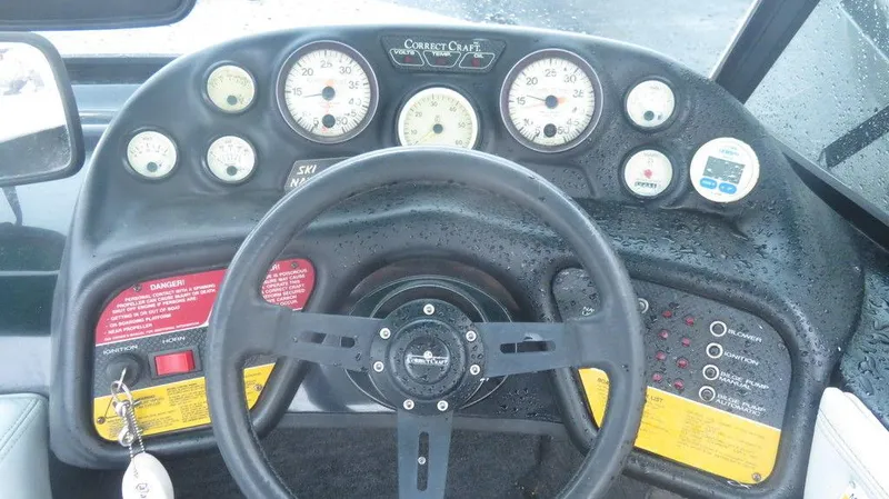 Slide: The Image of 1990 Nautique Ski boat dashboard with steering wheel and instrument gauges. - 8