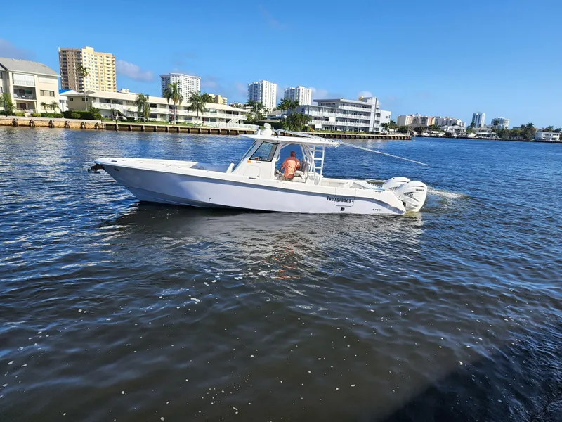 Slide: The Image of 2019 Everglades 365 boat cruising on a sunny day near waterfront buildings. - 6