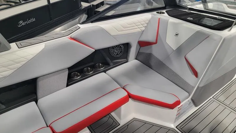 Slide: The Image of 2022 Nautique Super Air Nautique S23 interior with modern seating and red accents. - 11