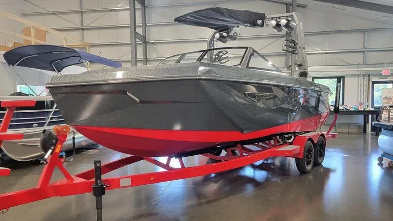 Slide: The Image of 2022 Nautique Super Air Nautique S23 boat in showroom, gray with red accents. - 3