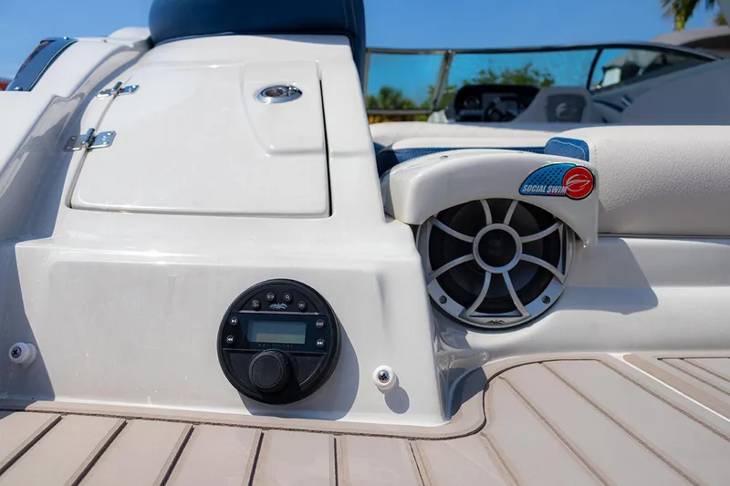 Slide: The Image of 2022 Crownline E 255 XS boat deck with audio system and storage compartment. - 23