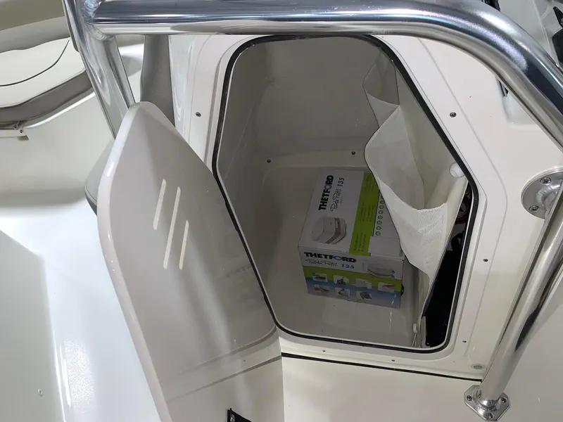 Slide: The Image of Storage compartment on a 2024 Key West 203 FS boat with a Thetford Porta Potti. - 6