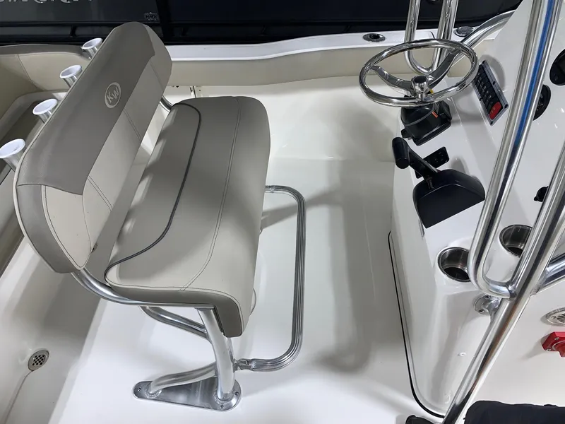 Slide: The Image of 2024 Key West 203 FS boat interior with steering console and cushioned seating. - 7