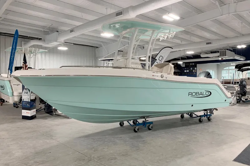 Slide: The Image of 2024 Robalo R222 Explorer boat in showroom, mint green hull, white interior. - 0