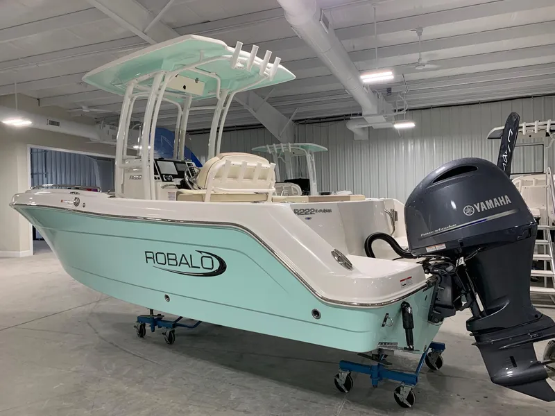 Slide: The Image of 2024 Robalo R222 Explorer boat with Yamaha outboard motor in a showroom. - 1