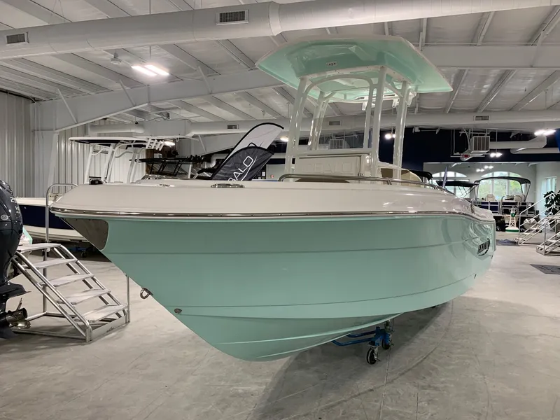 Slide: The Image of 2024 Robalo R222 Explorer boat in showroom, mint green hull, center console. - 2